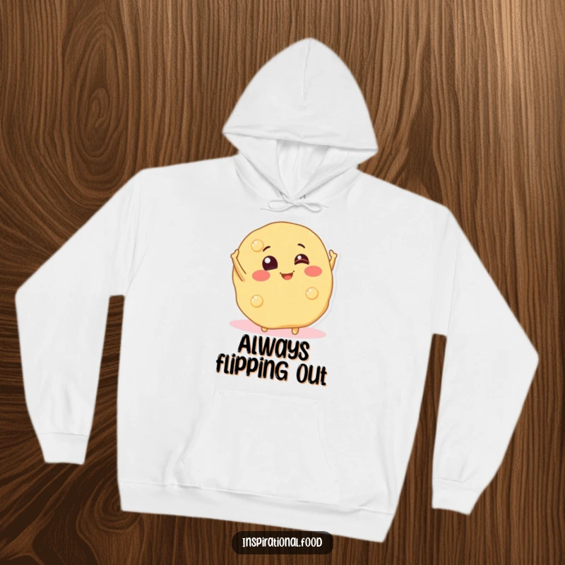 Funny hoodie adorned with a cheerful pancake character executing a playful mid-air flip, radiating cozy breakfast vibes.